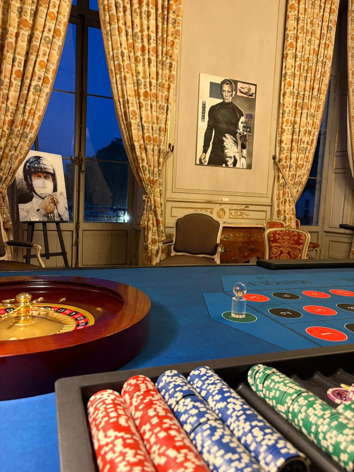 Roulette et piles de jetons de casino devant des affiches James Bond pendant la soirée